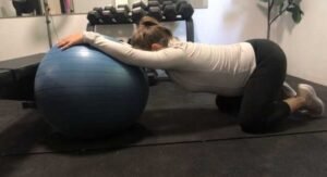 Child's pose stretch using exercise ball while pregnant.